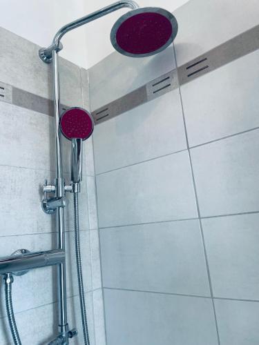 a shower with red shower heads on a wall at Airport Flower Home in Marina Julia