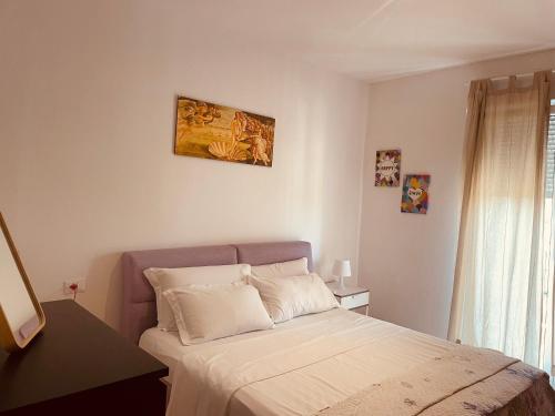 a bedroom with a bed and a painting on the wall at Airport Flower Home in Marina Julia