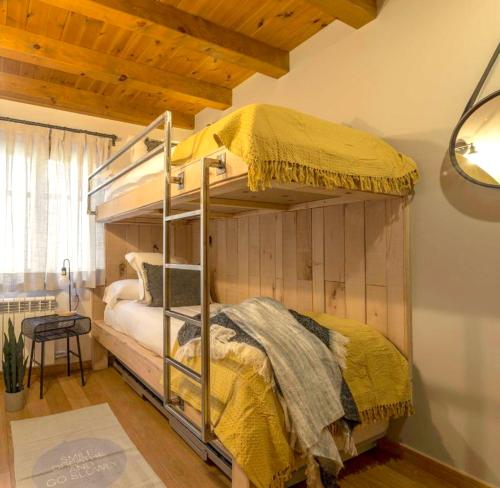 una camera con letto a castello e piumone giallo di Apartament familiar de luxe i balcó amb vistes by RURAL D'ÀNEU a València d'Àneu