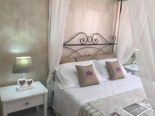 a bedroom with a white bed with a metal headboard at Mattandre in Monteroni di Lecce