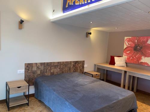 une chambre avec un lit et un panneau sur le mur dans l'établissement le loft de l'Atelier, à Nans-sous-Sainte-Anne