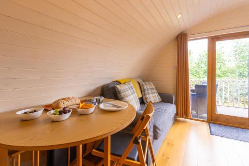 una sala da pranzo con un tavolo e un divano di Pod3 - Powys River Pods - Pet Friendly Glamping Pod Builth Wells Powys Wales a Garth