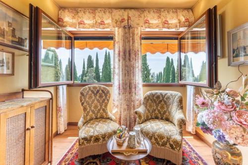 a living room with two chairs and a window at Villa Paradiso in Sirmione