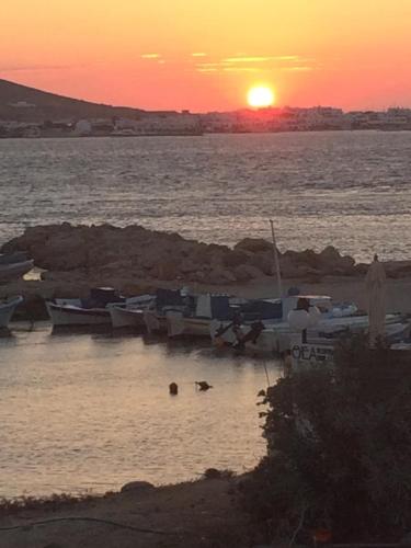 a group of boats in the water at sunset at Sunset Paros Antiparos treasure house, Pounta port in Kampos Paros