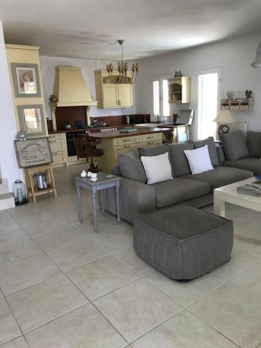 a living room with a couch and a kitchen at Sunset Paros Antiparos treasure house, Pounta port in Kampos Paros