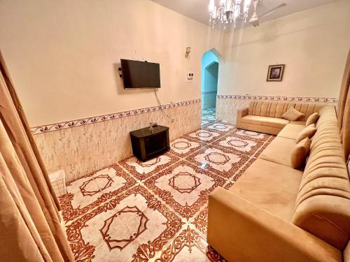 a living room with a couch and a tv at شقة عائلية 4 غرف في صلالة أثناء خريف ظفار in Salalah