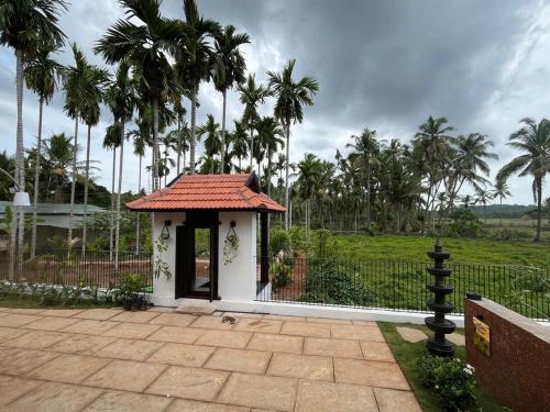 a small gazebo with a roof on a patio at Theeram - Whispers of the River in Kannur