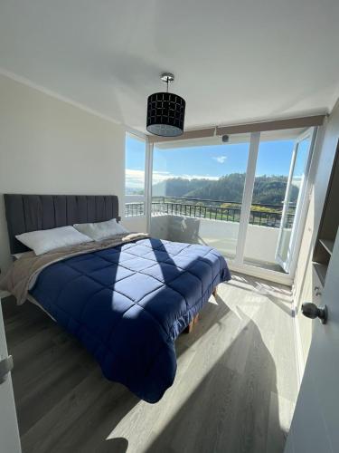 a bedroom with a bed and a large window at Hermoso departamento nuevo en Concepción 3 in Concepción