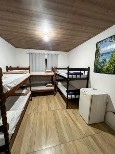 a room with three bunk beds and a ceiling at Hospedagem Doce lar in Joinville