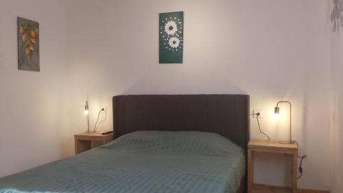 a bedroom with a bed and two lights on two tables at Casita Naranja in Alora