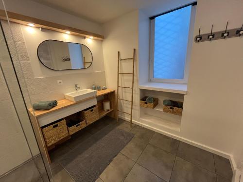 a bathroom with a sink and a mirror at Renote - Concept Appart Hôtel in Lannion