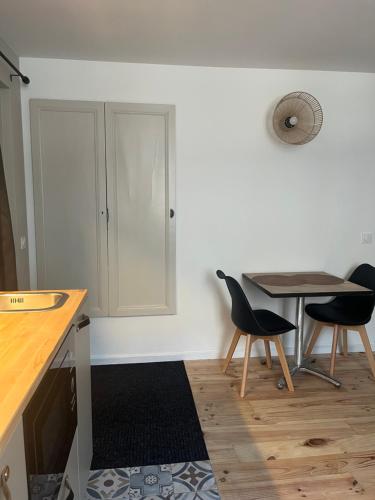 a kitchen with a table and two chairs and a table at Renote - Concept Appart Hôtel in Lannion