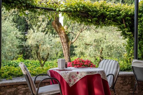 an outdoor table with a red table cloth and chairs at Villa Paradiso in Sirmione