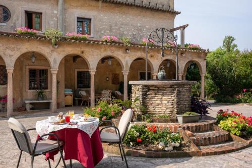 a table and chairs in front of a building with a fountain at Villa Paradiso in Sirmione