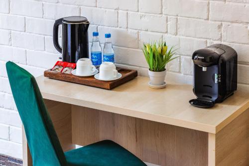 a table with a coffee maker and bottles of water at Solief Hotel in Katartal