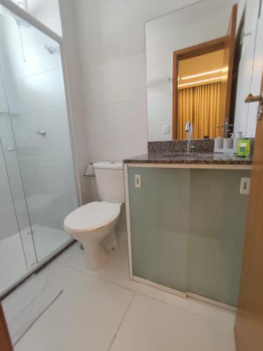 a bathroom with a toilet and a sink and a shower at Apartamento pé na areia in Ilhéus