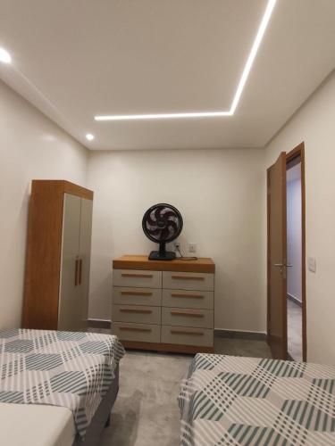a bedroom with two beds and a dresser at Apartamento pé na areia in Ilhéus