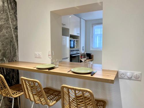 een keuken met een bar met stoelen en een aanrecht bij Haut Chatelet in Orléans