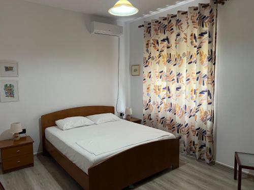 a bedroom with a bed with a curtain with birds on it at Rei's Apartment 2 in Tirana