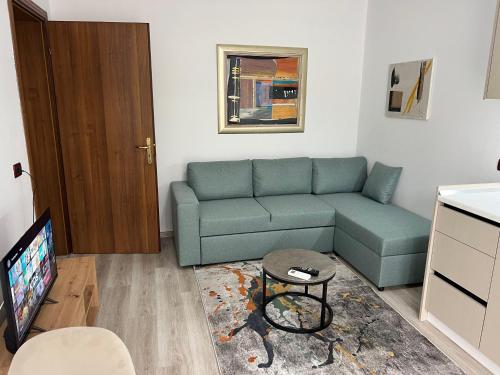 a living room with a couch and a tv at Rei's Apartment 2 in Tirana