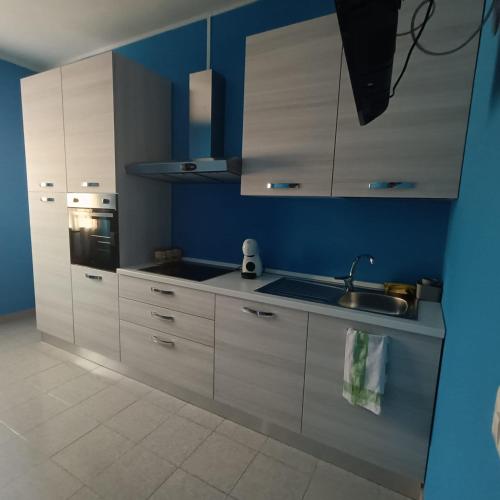 a kitchen with white cabinets and a sink at Casa blu free private parking on the see in Badesi