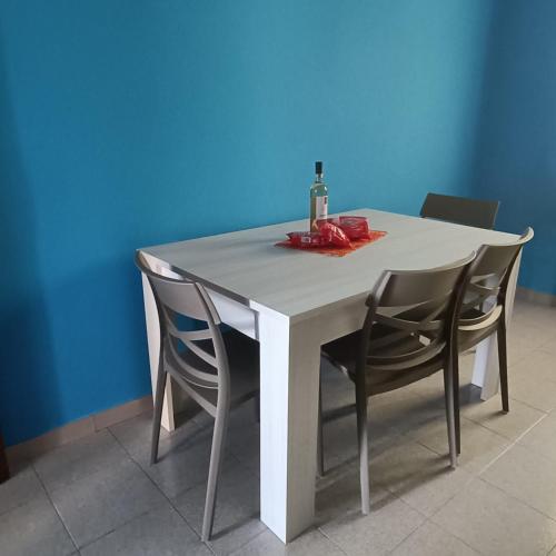 a white table with two chairs and a bottle of wine at Casa blu free private parking on the see in Badesi