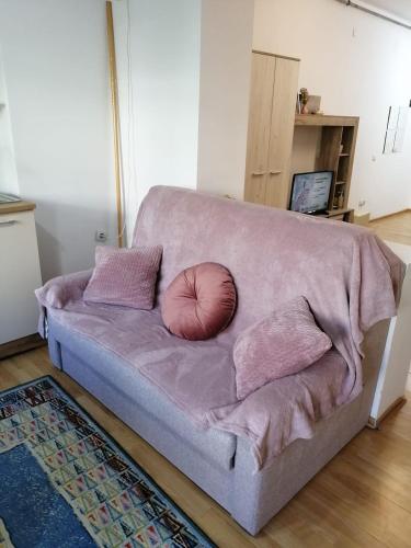 a couch with a pillow on it in a living room at Sofia Caffee Apart in Poiana Brasov