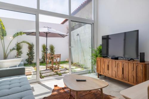 a living room with a tv and a couch and a table at Poets Atelier in Oeiras
