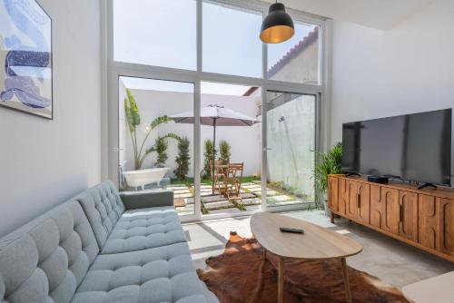 a living room with a couch and a tv and a table at Poets Atelier in Oeiras