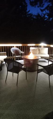 a patio with a table and chairs and a fire pit at Water Front Home with Private Dock and Hottub in Sooke