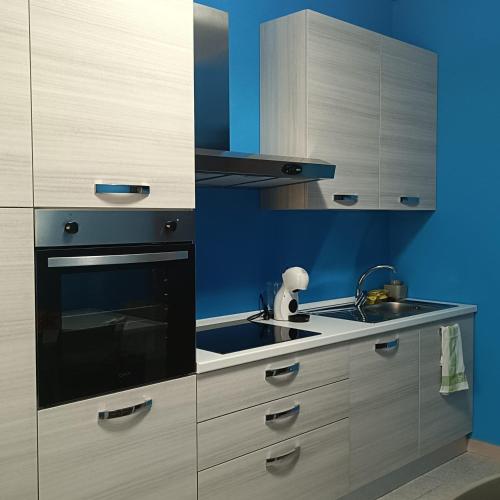 a kitchen with white cabinets and a sink at Casa blu free private parking on the see in Badesi