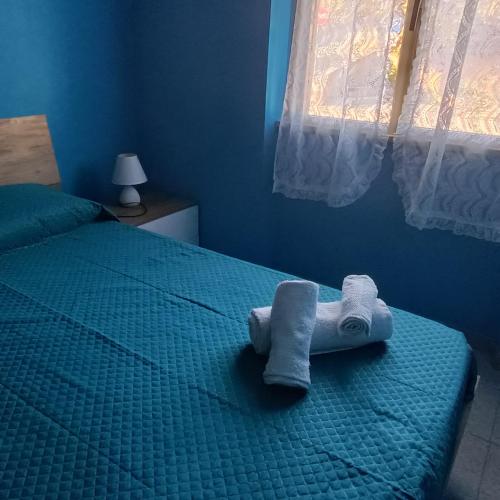 a blue bedroom with a bed with a towel on it at Casa blu free private parking on the see in Badesi