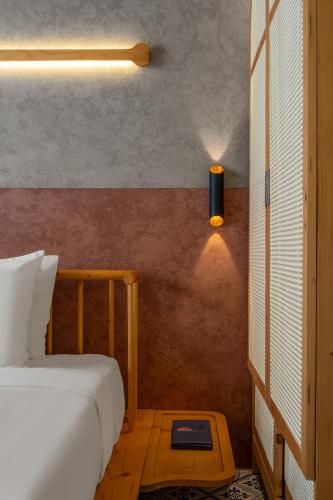 a bedroom with a bed and a light on the wall at Tropical An Bang Beach Villa in Hoi An