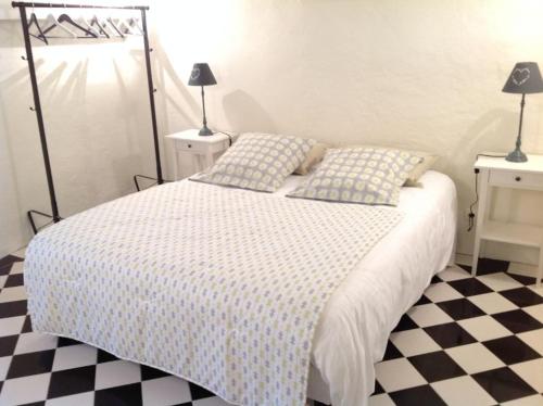 a bedroom with a bed and a checkered floor at Une petite pause en Tarn et Garonne in Castanet