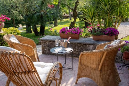 a patio with chairs and a table and flowers at Villa Paradiso in Sirmione