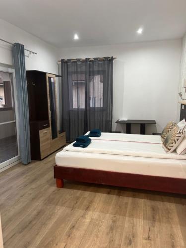 a bedroom with a large bed and a wooden floor at Vila Phoenix in Călimăneşti