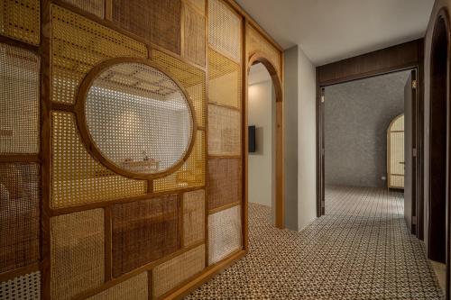 a hallway with a mirror on a wooden wall at Tropical An Bang Beach Villa in Hoi An