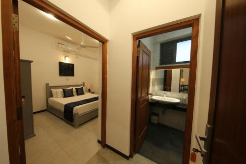 a bedroom with a bed and a sink and a mirror at Seilan in Colombo