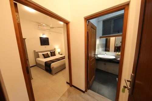 a bedroom with a bed and a bathroom with a sink at Seilan in Colombo