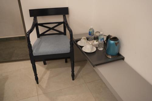 a black chair sitting next to a table with a tea set at Seilan in Colombo