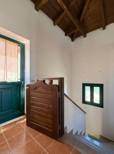 a room with a wooden door and a staircase at The Twin Houses in Metamórfosis