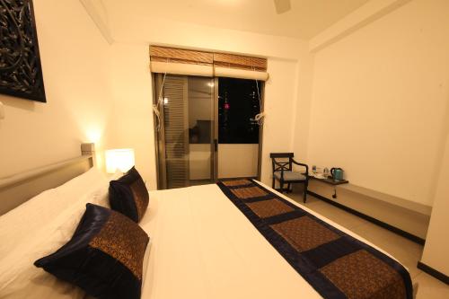 a bedroom with a large white bed with a window at Seilan in Colombo