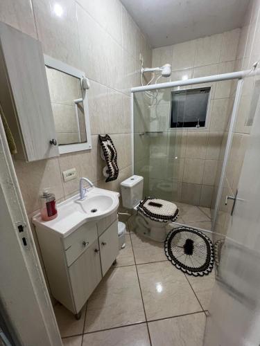 a bathroom with a shower and a sink and a toilet at Hospedagem Doce lar in Joinville