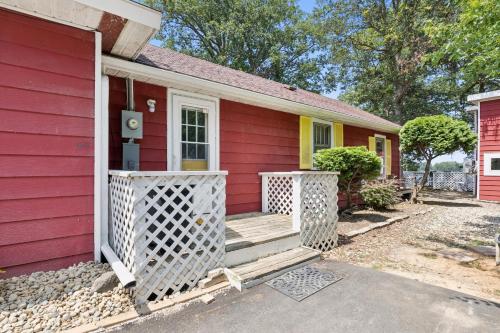 une maison rouge avec une porte rouge et une véranda dans l'établissement Dave's Last Resort-House on the Lake home, à Monticello
