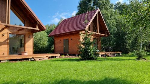 a log cabin with a large yard and a green field at Osada Iwiec-Karpaty 
