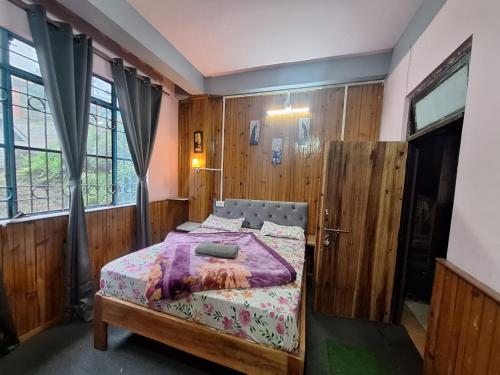 SonādaにあるSilent dragon hotelの木製の壁の部屋にあるベッドのある寝室