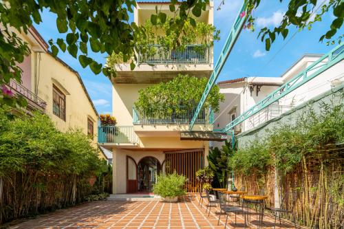 a courtyard with tables and chairs in a building at Tropical An Bang Beach Villa in Hoi An