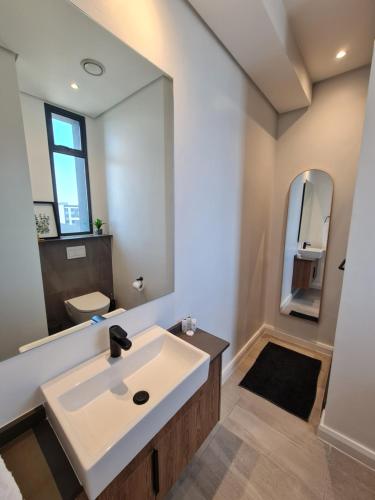 a bathroom with a sink and a mirror at Luxury Menlyn Maine Apartment in Pretoria