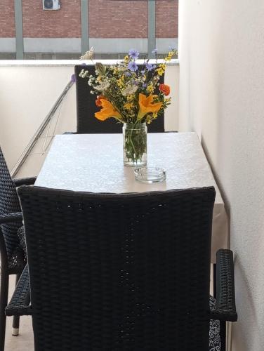 a table with a vase of flowers on top of it at Apartmani Mušinbegović in Visoko