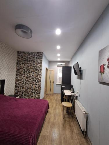 a bedroom with a bed and a desk with a computer at Апартаменти "PLATFORMA" поруч з Південним вокзалом in Kharkiv